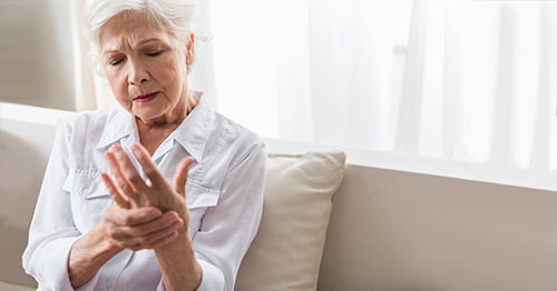 A woman holding her hands in pain.