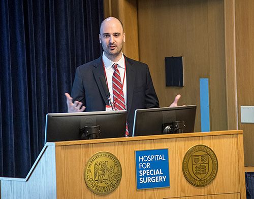 Image: Jonathan Avery, MD, speaking at a podium at HSS.