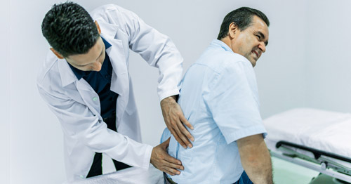 Doctor examining a patient's back.
