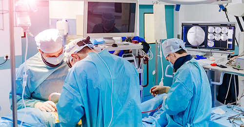 Surgeons in an operating room working on a patient.