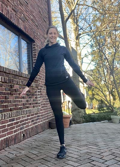 woman demonstrating standing alternating butt kicks