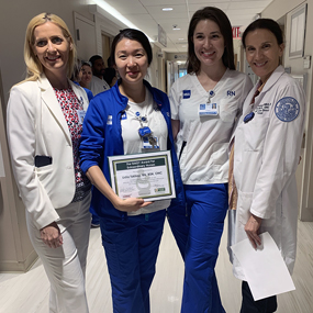 Photo of Lidia Tskhayholding her award alongside SVP and Chief Nursing officer Jennifer O'Neill and two other Nursing staff members