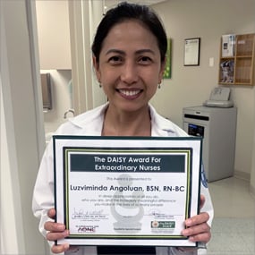 Photo of Luzviminda "Beng" Angoluan holding her DAISY Award.