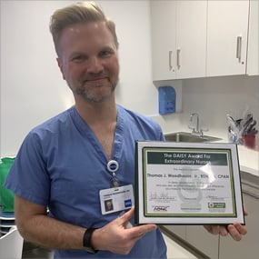 Photo of Thomas Woodhouse holding his DAISY Award