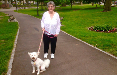 Senior woman walking her dog in the park