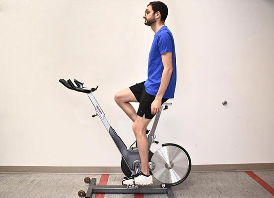 man on exercise bike demonstrating seat height position