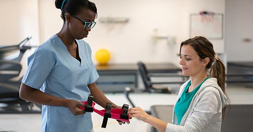 A healthcare worker fitting a wrist splint for a patient.