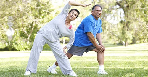 An older womoan and man doing hip and knee exercises.
