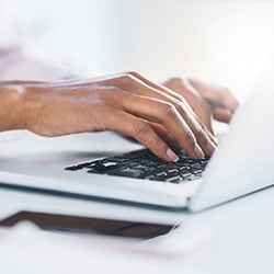 Hands typing on a keyboard.