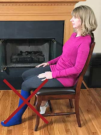 Photo of a woman sitting incorrectly with her left foot on the floor and not elevated as instructed