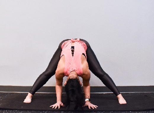 photo of cara demonstrating Wide-leg forward fold stretch