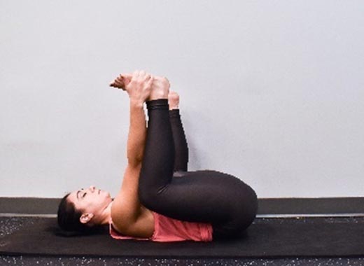 photo of cara demonstrating Happy Baby stretch