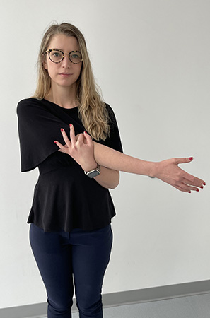 Image of woman stretching her right arm across the front of her chest Posterior capsule stretch