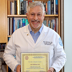 Dr. Seth Waldman holds his framed award