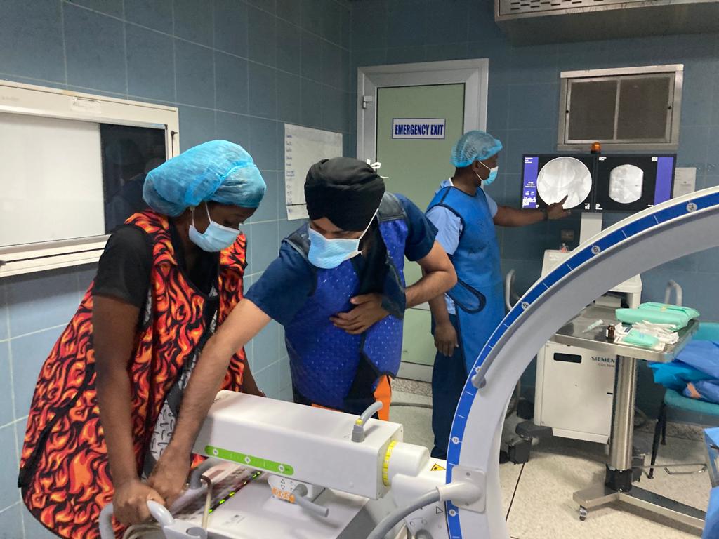 Dr. Harman Singh teaches Oby Ofungu how to use fluoroscopy