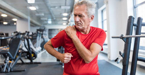 A man at the gym feeling shoulder pain.