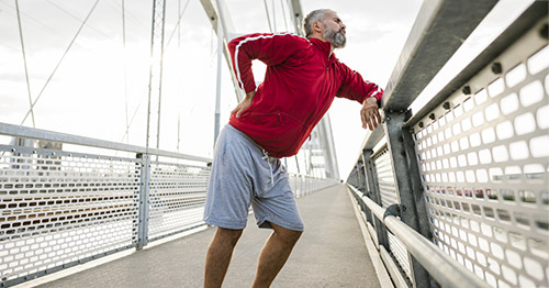 A man holding his lower back in pain.