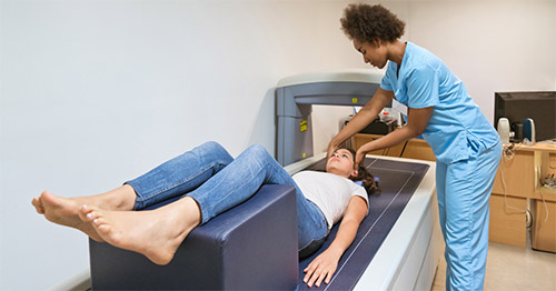 A young woman getting a DEXA bone scan.